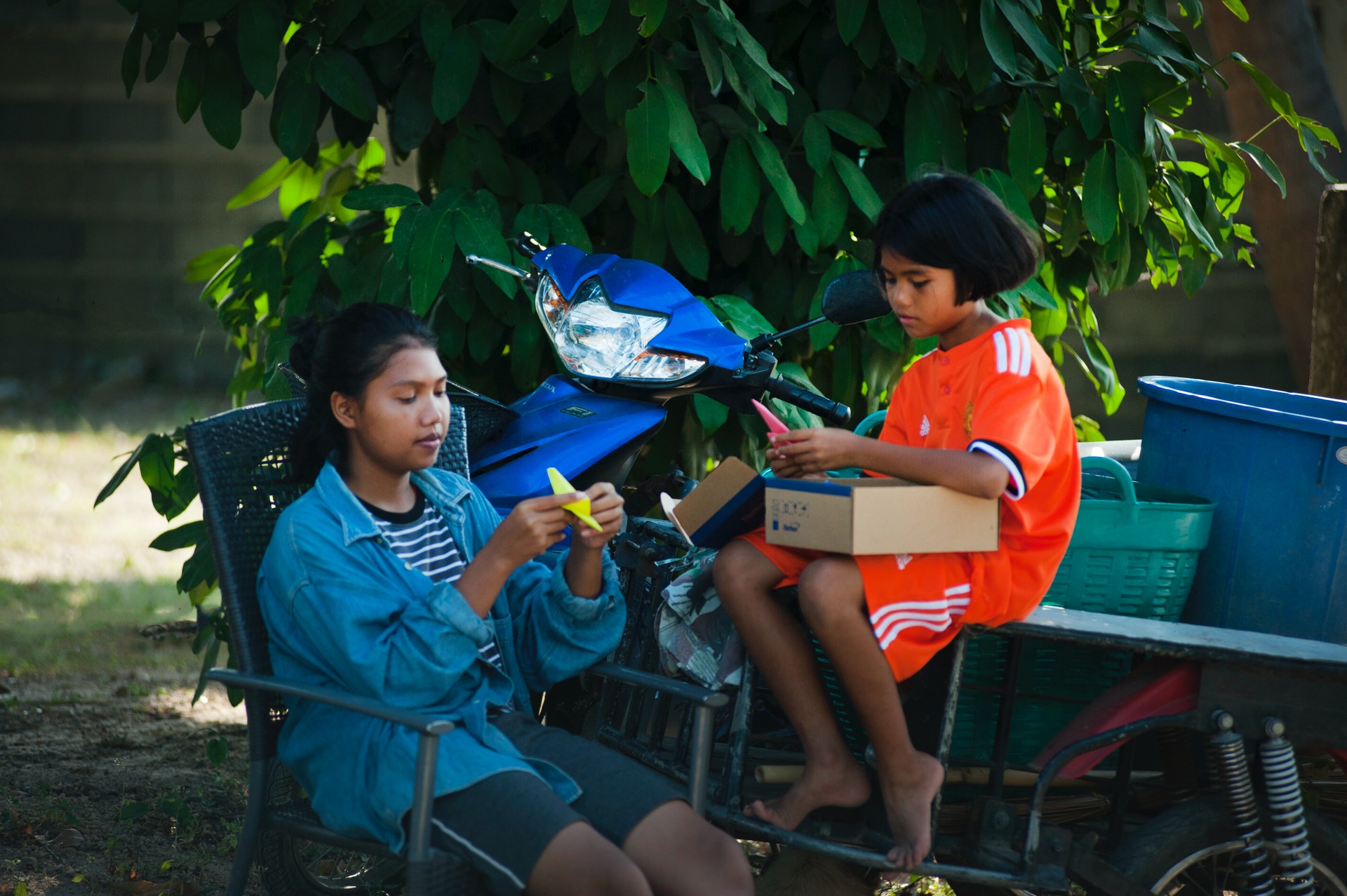 Two girls doing hand crafts in a rural setting