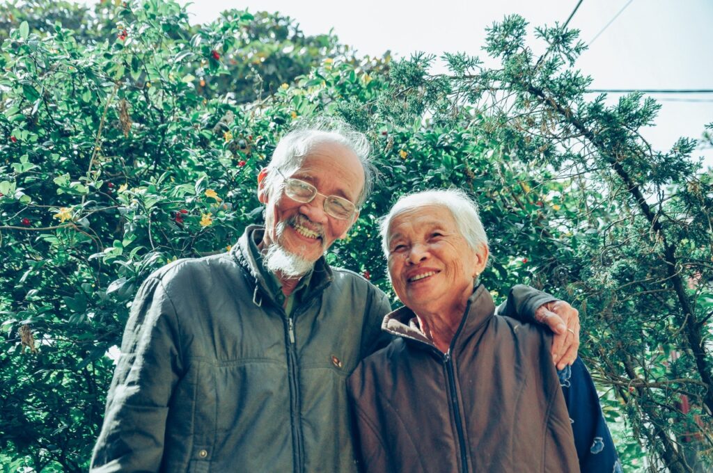 Grandparents smiling with trees in the background