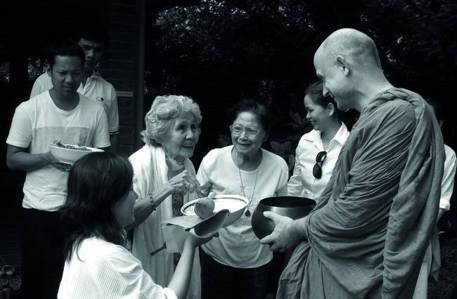 Image of monk Venerable Ajahn Jayasaro talking with a group of people