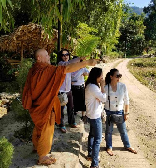 Group of volunteers with monk pointing in the distance