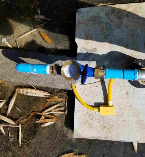 Top view of a water well pump with blue piping