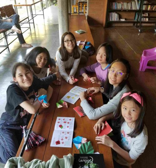 Volunteer girls seated doing crafts